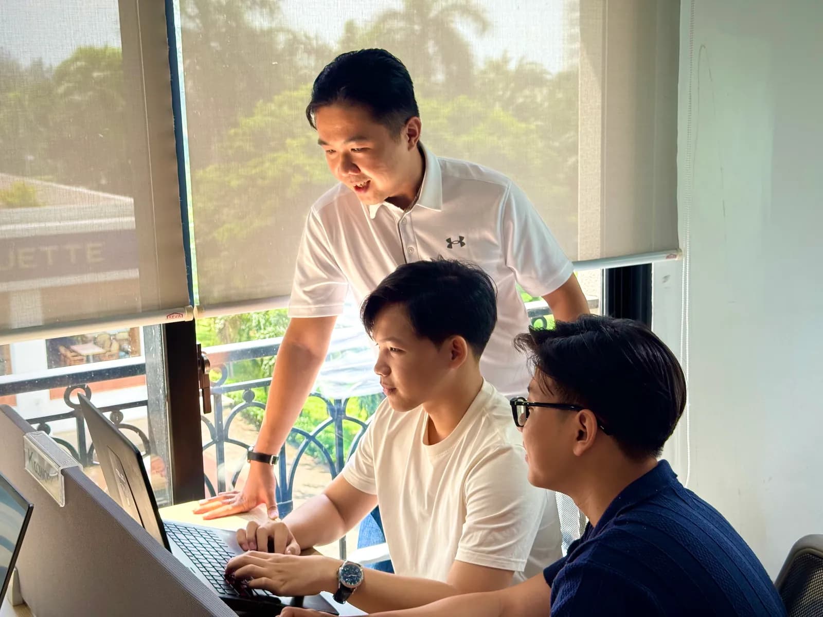 FIX Partner developers collaborating around a laptop in Ho Chi Minh City